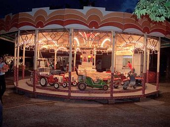 Nostalgisches Kinderkarussell mit Traktoren und Autos im Vintage-Stil