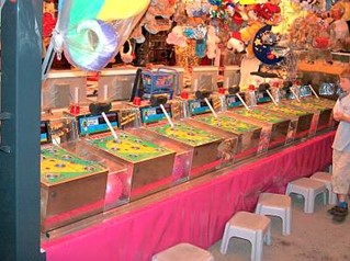 Traditionelle Spielbuden mit mechanischen Spielen und bunten Hintergründen