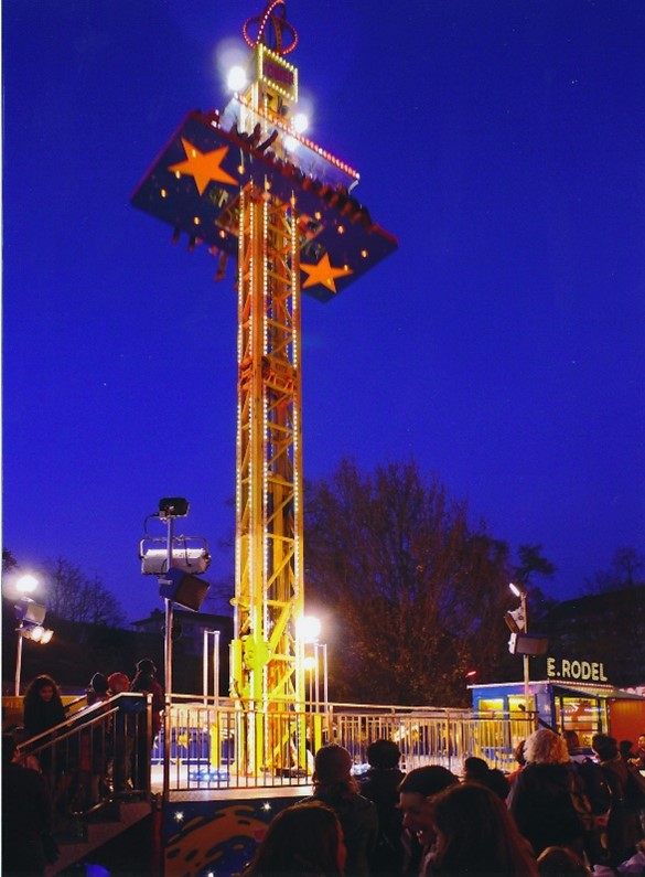 Ein beleuchteter Freifallturm bei Nacht